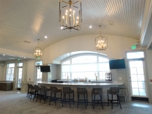 Union League Golf Club renovation- white curved bar with curved white paneled ceiling and pendant fixtures