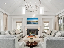 High peaked living area in white wood with porches and fireplace
