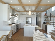 White and warm natural wood tie this kitchen and living area together