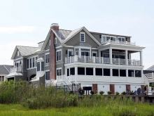 Oversized custom bayfront home with classic white porches and traditional details.
