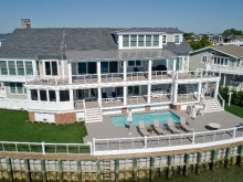 Large end of cul de  sac bayfront takes in the views with double porches, a pool and docks.