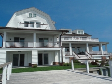 Classic Stone Harbor style custom construction home on bayfront corner lot with pool, docks and porches. gabled roof